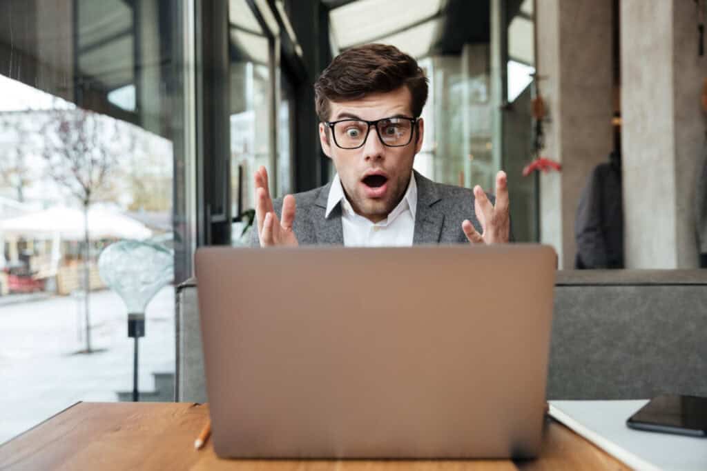 Frustrated man with glasses looking at laptop, digital marketing, web design, SEO expert, online business stress.