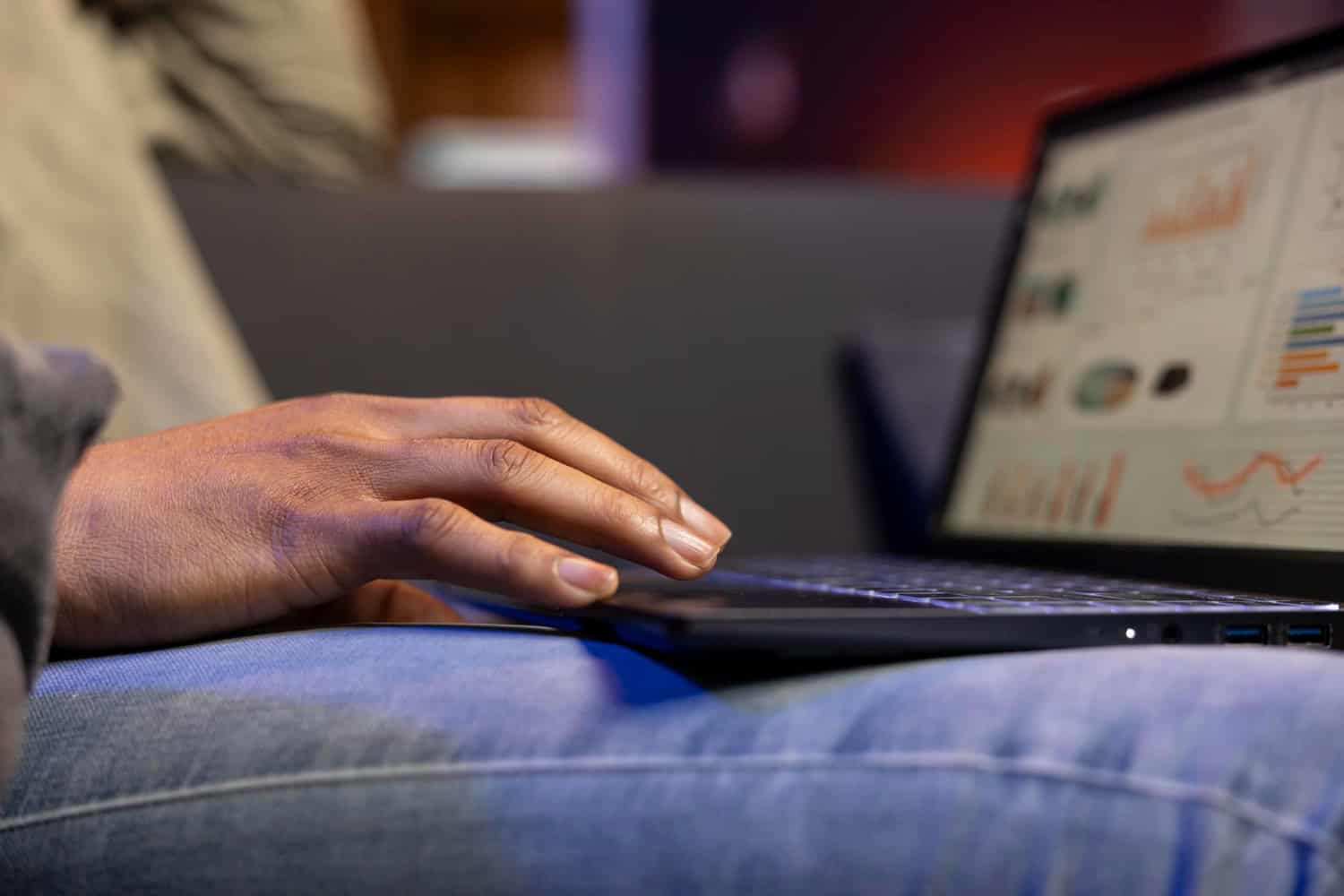 Hand working on a laptop with SEO analytics dashboard and charts, digital marketing and website optimisation in focus.