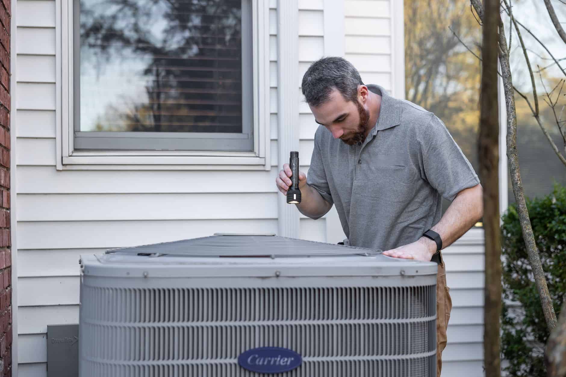 Engineer inspecting an outdoor heat pump unit