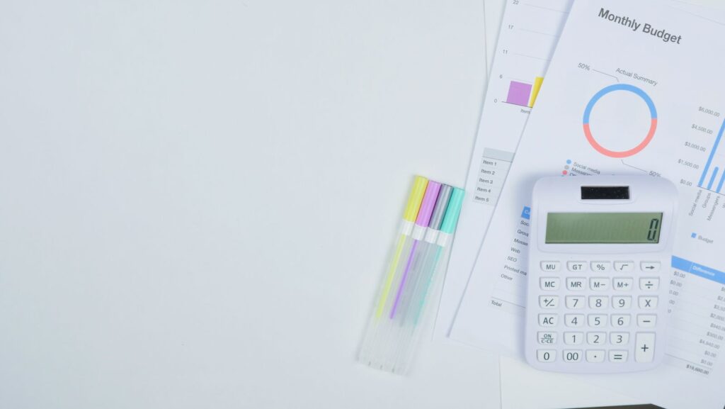 Desk with a calculator and budget planning sheets, used to work out the cost of a business website